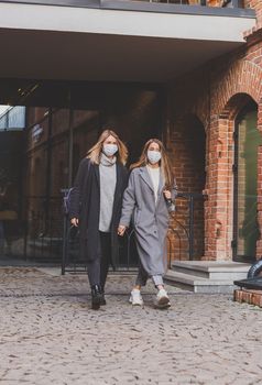 Young pretty girls friends having fun outdoor in autumn evening in city laughing and going crazy on the street - friendship and funny people