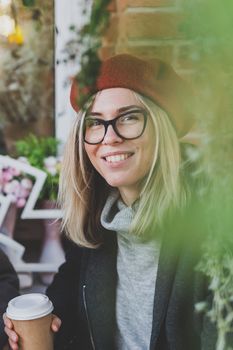 Portrait of young beautiful woman sitting in a cafe outdoor drinking coffee