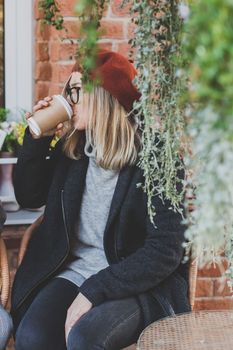Portrait of young beautiful woman sitting in a cafe outdoor drinking coffee