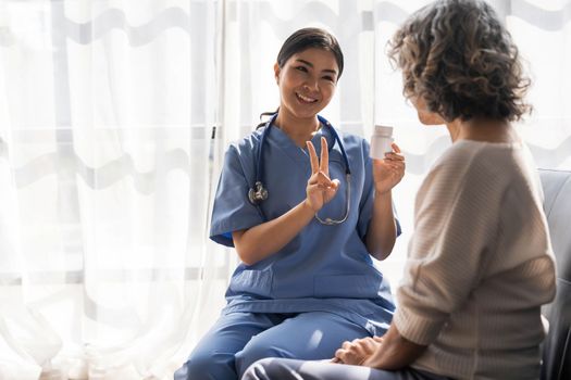 Healthcare worker or nurse caregiver giving pills, showing a prescription drug to senior woman. Elderly healthcare concept..