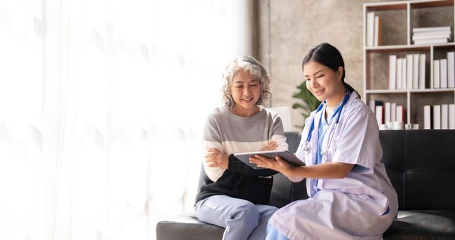 Young caregiver helping senior woman walking. Nurse assisting her old woman patient at nursing home. Senior woman with walking stick being helped by nurse at home...