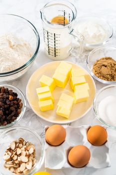 Measured ingredients in glass mixing bowls to bake mini Easter bread kulich.