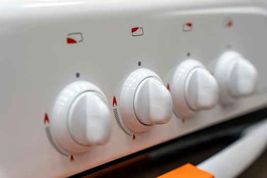 the handle for turning on the burner of a home kitchen stove. close-up. Home gas stove. The job in the kitchen. Control knobs of electric stove close-up