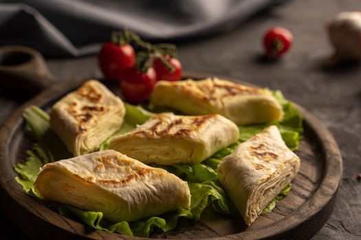 Delicious fried pita bread roll with cottage cheese and herbs. Fried puff rolls of thin Armenian lavash stuffed with cottage cheese. Wrapped tortillas. Traditional cuisine. Delicious and healthy food.