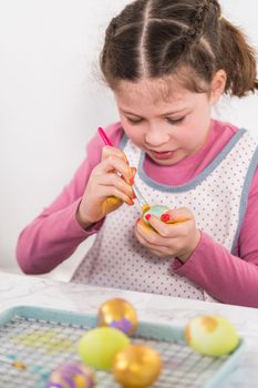 Easter egg coloring. Painting Easter eggs with gold luster.