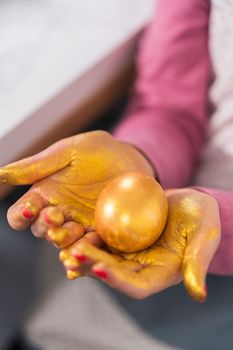 Easter egg coloring. Painting Easter eggs with gold luster.