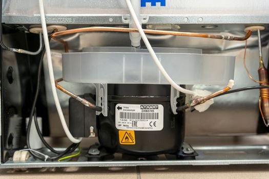 Sosnovy Bor, RUSSIA - JANUARY 12, 2023: household appliances in DNS store, refrigerator. The back of the refrigerator with a radiator grille and compressor, tubes with refrigerant