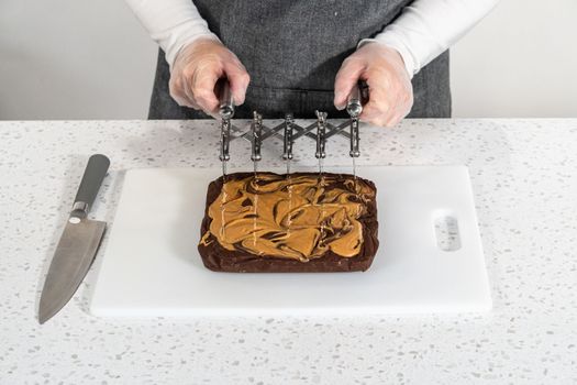 Scoring chocolate fudge with peanut butter swirl for cutting into small pieces.
