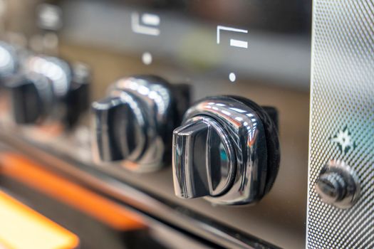 the handle for turning on the burner of a home kitchen stove. close-up. Home gas stove. The job in the kitchen. Control knobs of electric stove close-up