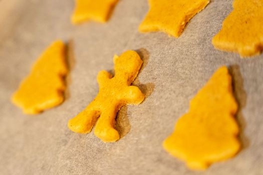 unbaked cookies on a baking sheet from the oven, close-up of various shapes of cookies. figurines, cookies, baking sheet, baking paper. background