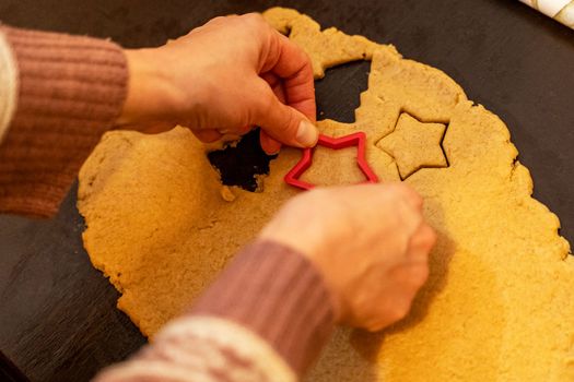 Dough, cookie cutters, mold. Dough for preparing cookies. molds on table. hands making cookies. cutting the dough with the molding trim.