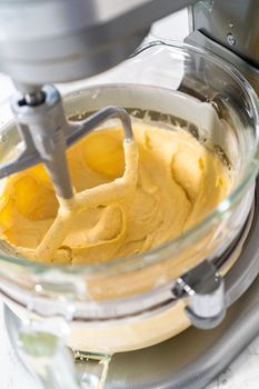 Mixing ingredients in kitchen mixer to bake mini Easter bread kulich.