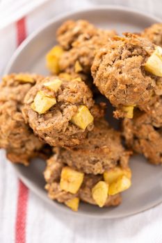 Freshly baked apple oatmeal with apple chunks cookies on small plate.
