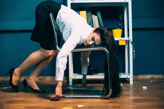 Tired businesswoman sleeping on office chair. Young exhausted pretty girl resting in unnatural pose, falling asleep on the go. Tinted image.