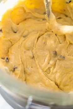 Mixing ingredients in kitchen mixer to bake mini Easter bread kulich.