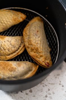 Frying sweet cherry empanadas in the air fryer.