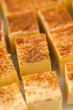 Homemade eggnog fudge pieces on a white cutting board.
