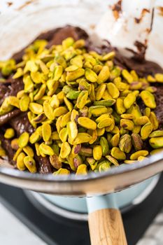 Melting white chocolate chips and other ingredients in the double boiler to prepare chocolate pistachio fudge.