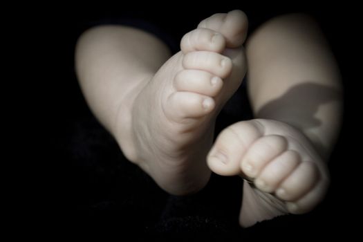 Baby feet on black background. Tranquil scene