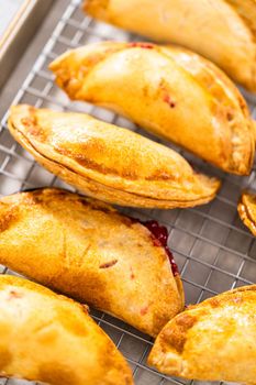 Freshly baked sweet cherry empanadas in the air fryer on the kitchen counter.