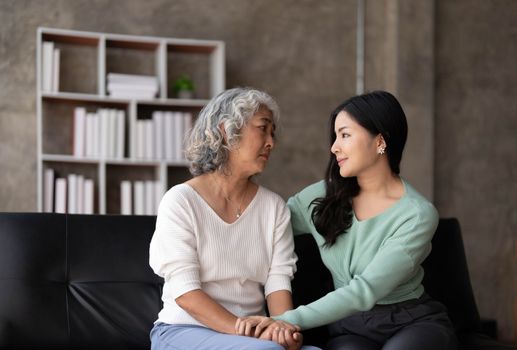 Young woman comforting her discontent or offended aged mother.