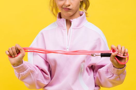 Adorable female child with skipping rope jumping in a studio