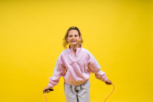 Adorable female child with skipping rope jumping in a studio