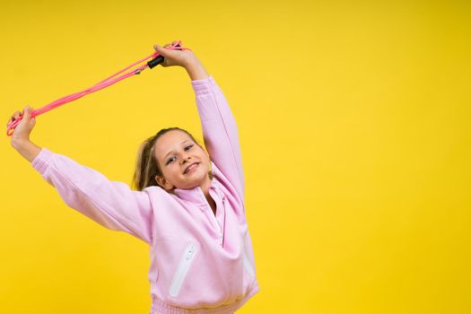Adorable female child with skipping rope jumping in a studio