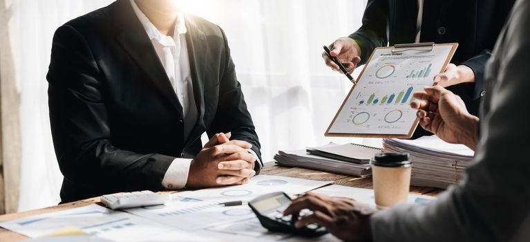 Business People Meeting using laptop computer,calculator,notebook,stock market chart paper for analysis Plans to improve quality next month.