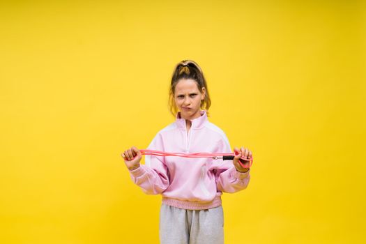 Adorable female child with skipping rope jumping in a studio