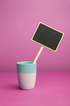 Coffee Cup Standing on Desk. Important infrormation written on paper.