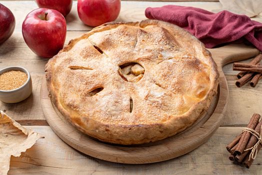 Autumn food. Homemade apple pie with fresh red apples on wooden table