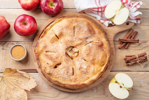 Autumn food. Homemade apple pie with fresh red apples on wooden table