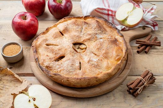 Autumn food. Homemade apple pie with fresh red apples on wooden table
