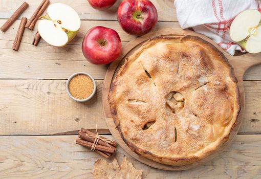 Autumn food. Homemade apple pie with slice with fresh red apples on wooden table