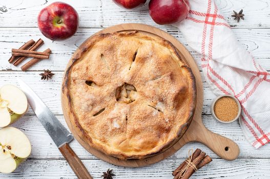 Autumn food. Homemade apple pie with fresh red apples on wooden table