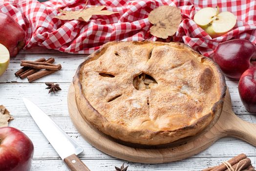 Autumn food. Homemade apple pie with fresh red apples on wooden table