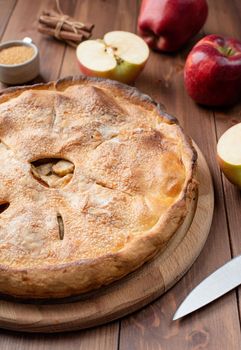 Autumn food. Homemade apple pie with fresh red apples on wooden table