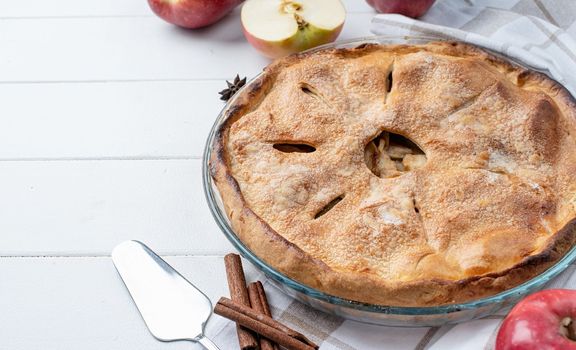 Autumn food. Homemade apple pie with fresh red apples on wooden table