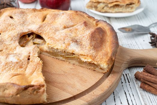 Autumn food. Homemade apple pie with slice with fresh red apples on wooden table