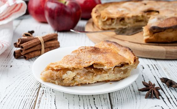 Autumn food. Homemade apple pie with slice with fresh red apples on wooden table