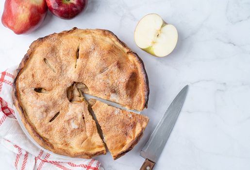 Autumn food. Homemade apple pie with slice with fresh red apples on wooden table