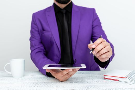 Man in jacket sitting at white table And Pointing With Pen On Message.