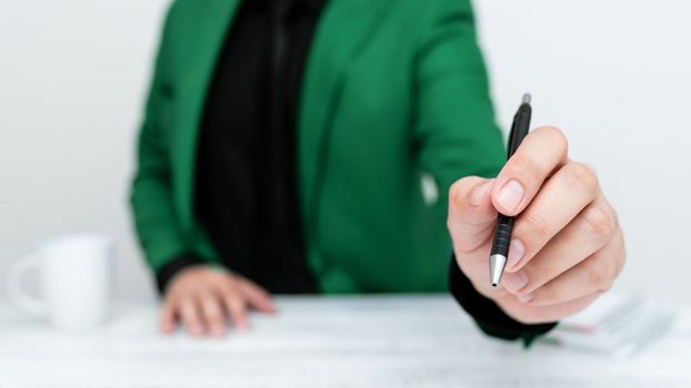 Male mode sitting at table And Pointing With Pen On Important Message.