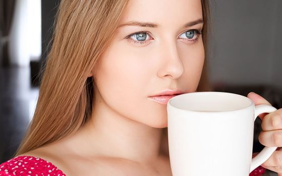 Beautiful woman having a cup of tea in the morning at home.