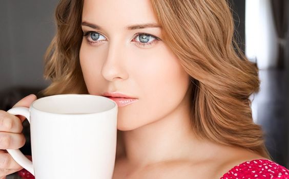 Beautiful woman having a cup of tea in the morning at home.