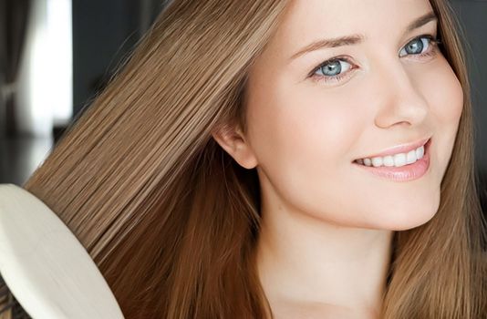 Beautiful happy woman combing her long hair.