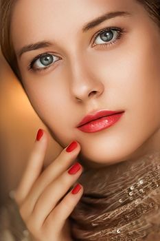 Beauty, makeup and glamour, face portrait of beautiful woman with manicure and red lipstick make-up wearing gold for luxury cosmetics, style and fashion look