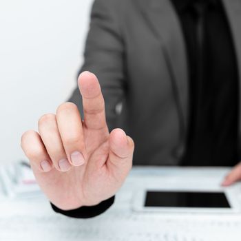 Businessman sitting at table And Pointing With One Finger On Message.