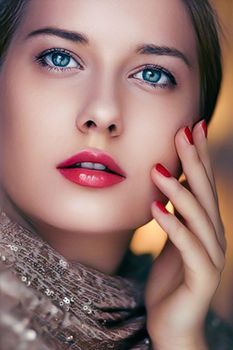 Beauty, makeup and glamour, face portrait of beautiful woman with manicure and red lipstick make-up wearing gold for luxury cosmetics, style and fashion look